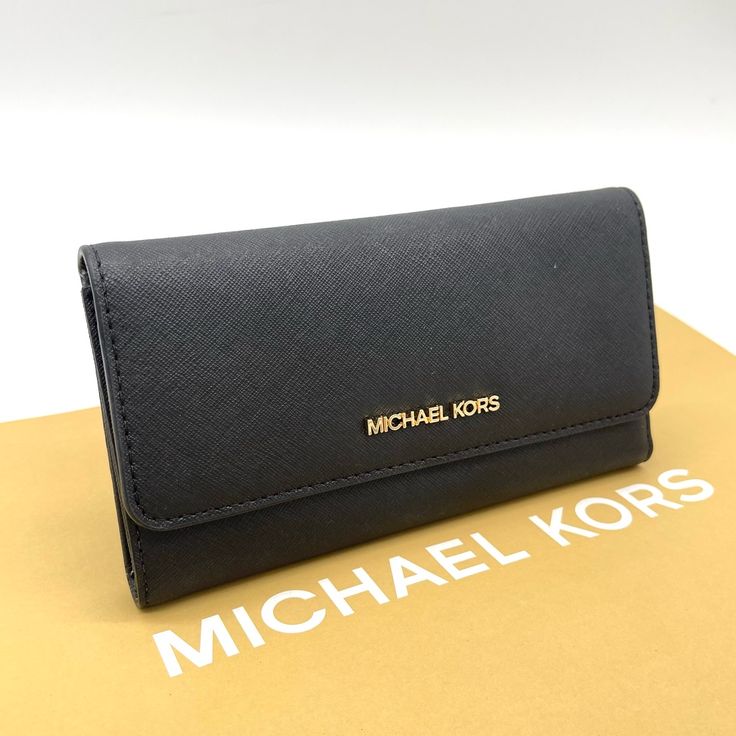 Brand New With Tag Michael Kors Jet Set Travel Item Trifold Wallet Saffiano Leather Color: Black Gold Tone Hardware Michael Kors Lettering Logo On Front Trifold Wallet W/ Snap Button Closure Full Length Zippered Pocket W/ Leather Pull On Back Interior: 1 Window Id, 4 Full Bill Slots, & 17 Credit Card Slots. Mk Signature Logo Fabric And Saffiano Leather Lining 7.5" W X 4" H X 0.75" D Black Trifold Wallet For Evening, Elegant Michael Kors Wallets With Card Slots, Michael Kors Leather Evening Wallet, Michael Kors Leather Wallets For Evening, Formal Black Trifold Wallet, Elegant Michael Kors Wallet For Travel, Elegant Michael Kors Wallets For Daily Use, Classic Michael Kors Wallet For Everyday Use, Michael Kors Classic Travel Wallet