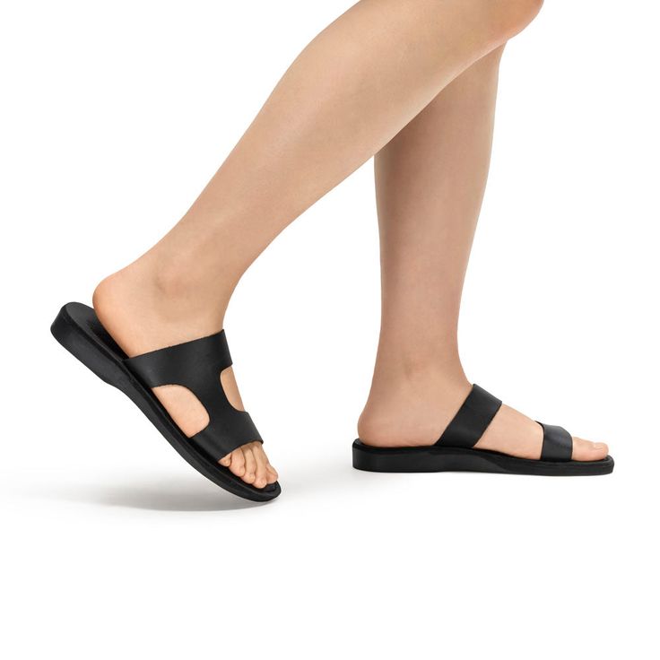 Meet 'June'—the epitome of effortless chic for the contemporary woman. This sandal is a fusion of simple elegance and practical design, ideal for those who appreciate subtlety with a touch of class. 'June' is crafted from soft, black leather, ensuring both comfort and longevity. Its broad, asymmetrical straps offer a modern aesthetic while providing a secure fit that’s perfect for day-long wear. Whether paired with a breezy summer dress or your go-to jeans, the 'June' sandal is versatile enough Minimalist Black Sandals For Spring, Chic Black Toe Ring Sandals For Summer, Modern Black Everyday Sandals, Minimalist Single Toe Strap Sandals For Spring, Modern Black Sandals For Summer, Modern Open Toe Toe Ring Sandals For Summer, Modern Toe Ring Sandals For Beach And Summer, Modern Toe Ring Sandals For Summer Beach, Modern Toe Ring Sandals For Summer