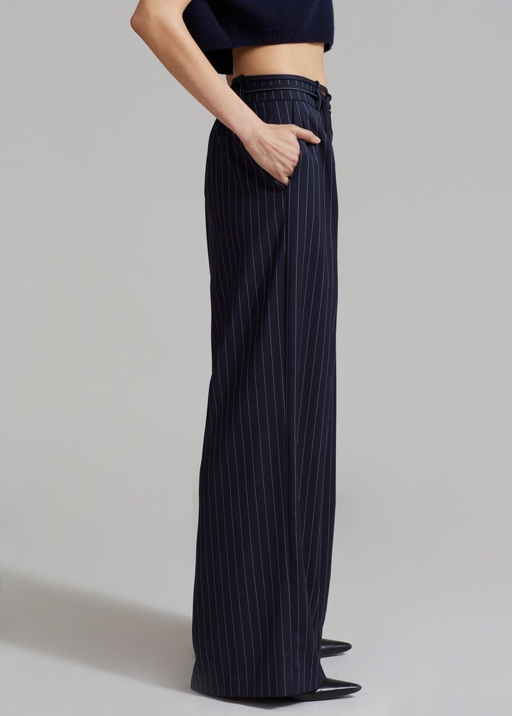 Color: Navy Pinstripe Lightweight woven fabric Relaxed silhouette Wide leg Elastic back Inverted pleat detail Belt loops with detachable tie string Slant hip pockets Front button closure Zip fly Unlined 80% Polyester 18% Rayon 2% Elastane Dry Clean By The Frankie Shop. Imported Navy Wide Leg Pants With Welt Pockets, Navy Bottoms With Side Pockets For Work, Tailored Straight Pants With Vertical Stripes, Tailored Striped Bottoms For Work, Formal Striped High Waist Bottoms, Striped Formal Bottoms With Welt Pockets, Formal Striped Bottoms With Welt Pockets, Tailored Striped Tapered Leg Bottoms, Navy Workwear Pants With Side Pockets