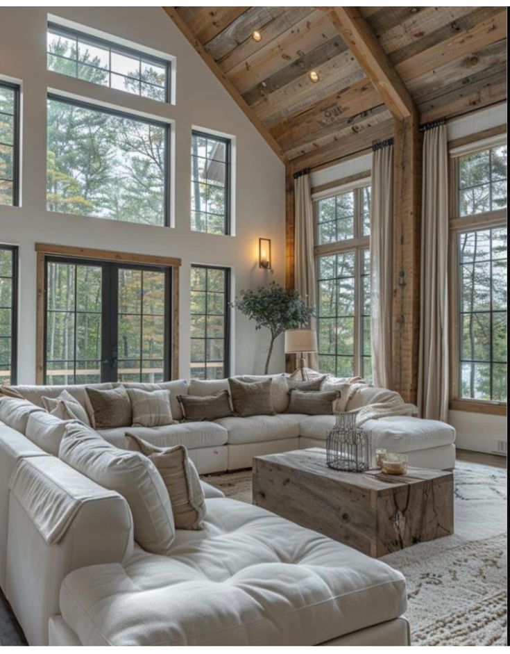 a living room filled with white furniture and lots of windows on the wall next to each other