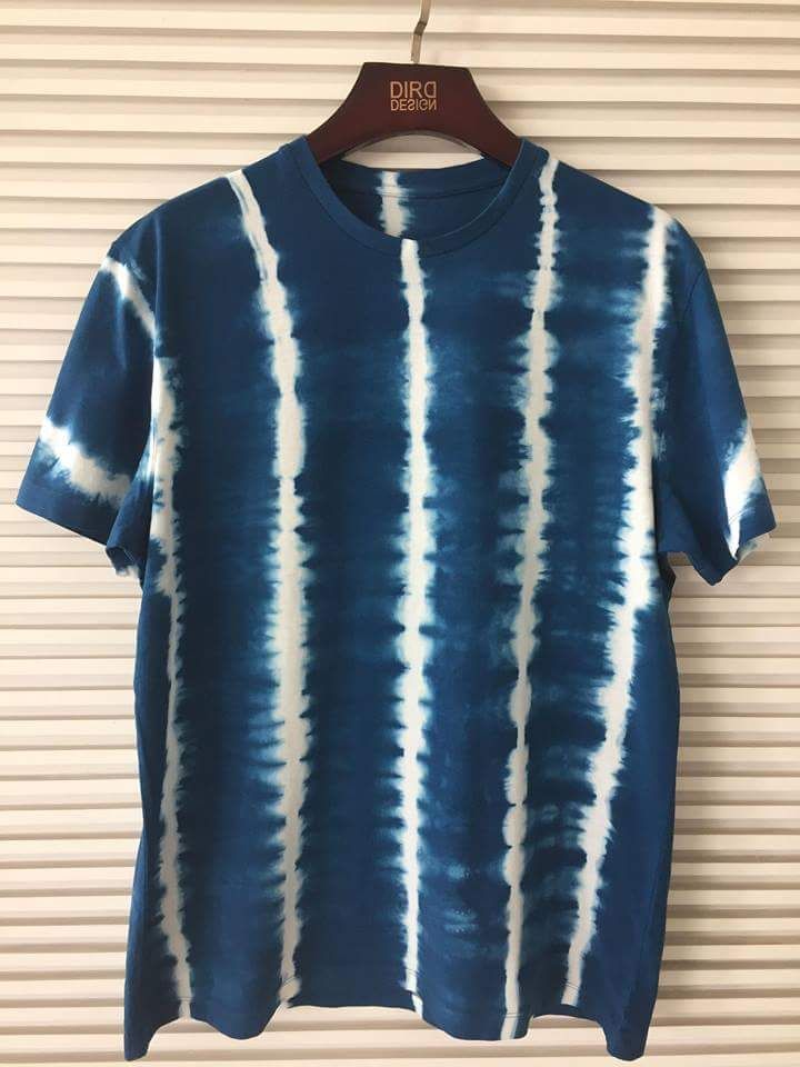 a blue and white tie dye shirt hanging on a wall