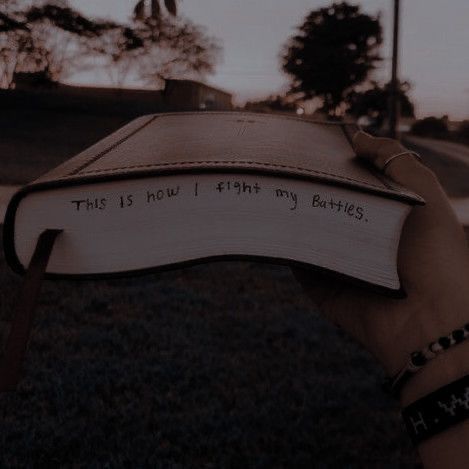 someone holding up a book with the words this is new i think my battles written on it