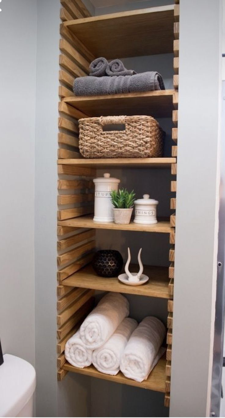 the shelves in this bathroom are filled with towels and other things to put on them