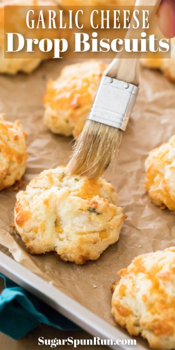 garlic cheese drop biscuits being brushed with a brush