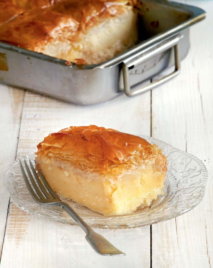 a piece of pie sitting on top of a glass plate next to a metal pan