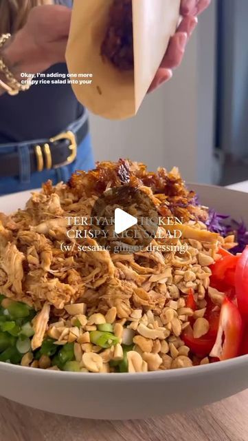 a woman is pouring dressing over a bowl of food with vegetables and rice on the side