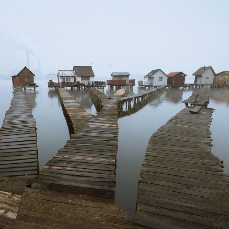 there are many houses on the water that is very foggy and it looks like they're floating in the ocean