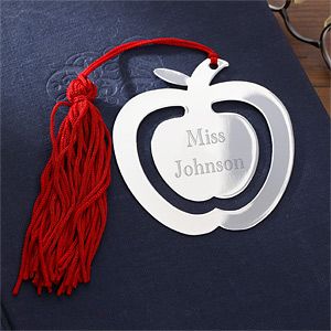 an apple shaped ornament with a tassel hanging from it