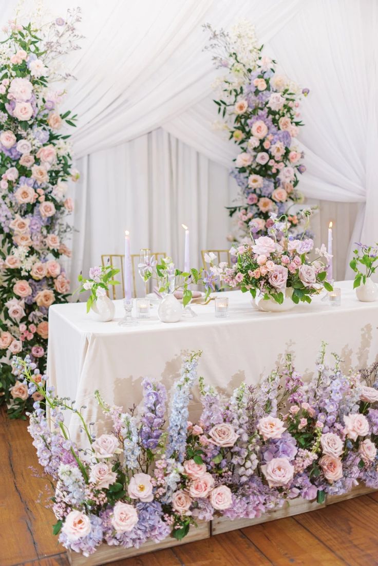 the table is covered with flowers and candles