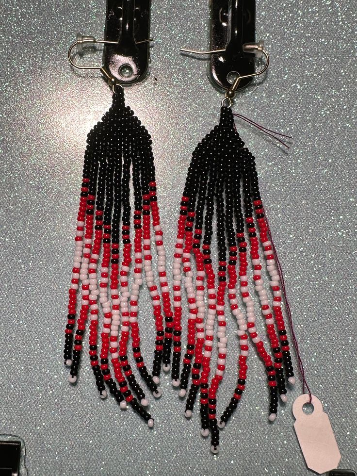 red, white and black beaded earrings on display