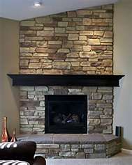 a living room with a stone fireplace and couches in front of the fire place