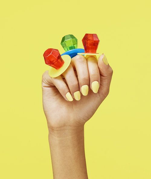 a woman's hand holding three small pieces of gummy bears on top of each other