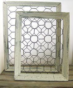 two white frames sitting on top of a wooden shelf