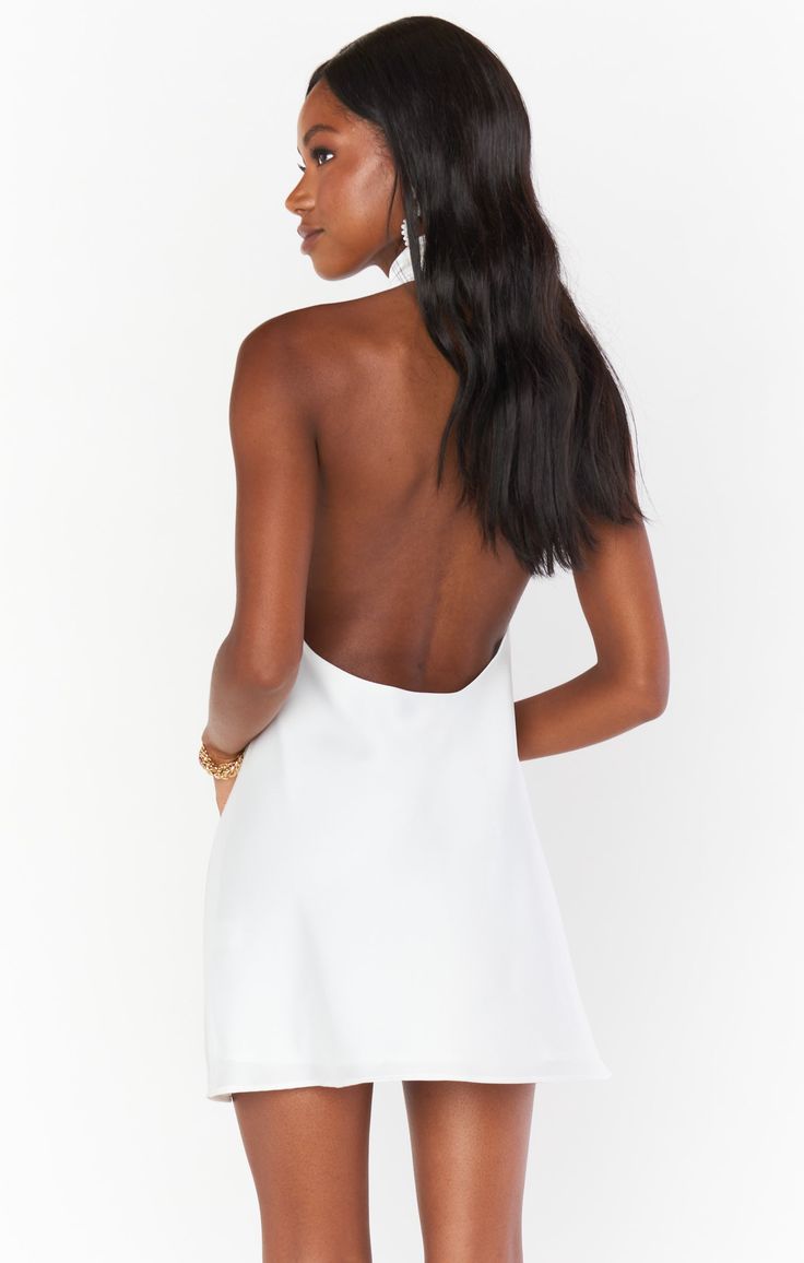 Our best selling halter maxi is now in mini length! This white mini is cut on the bias to give that perfect slip draping we're all looking for. The top softly wraps around your neck for a flattering high neck and leaves a dramatic open back. Beyond chic for a bridal shower and a new go-to for special occasions and events! Chic Spaghetti Strap Backless Dress With Cutout Back, White Backless Mini Dress For Date Night, Chic Backless Dress With Spaghetti Straps And Cutout Back, Chic Halter Dress With Cowl Back For Evening, Sleek White Sleeveless Mini Dress, White Spaghetti Strap Backless Dress For Date Night, Chic White Backless Dress For Night Out, Halter Neck Mini Dress With Tie Back For Wedding, Sleek Halter Neck Slip Dress For Summer