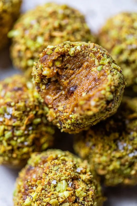 several balls of food sitting on top of a white plate with green sprinkles