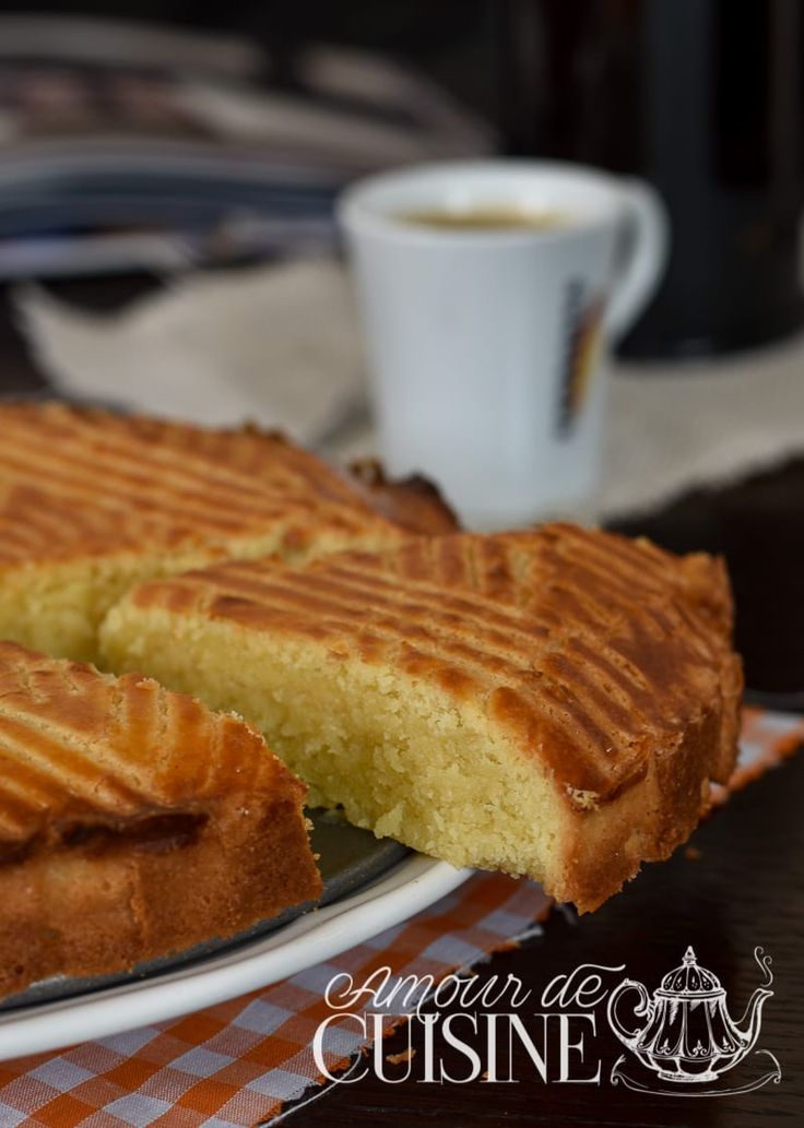 a plate with some cake on it and a cup of coffee in the back ground