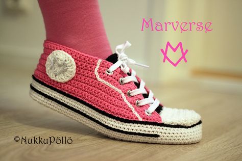 a close up of a person's feet wearing pink and white crocheted shoes