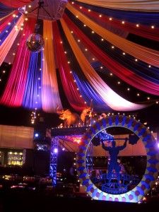 an elaborate decorated stage with lights and curtains on it's ceiling is lit up at night