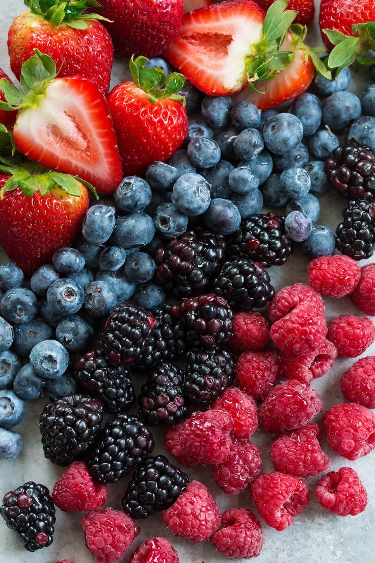 strawberries, blueberries and raspberries are arranged in the shape of an american flag