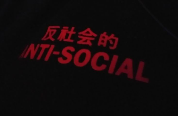 the words in chinese are lit up on a black shirt that says, it's social