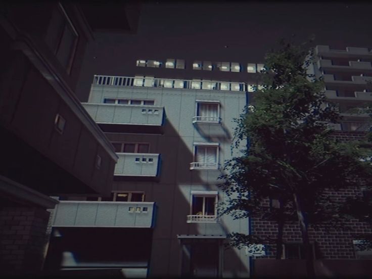 an apartment building with balconies and trees in the foreground, at night