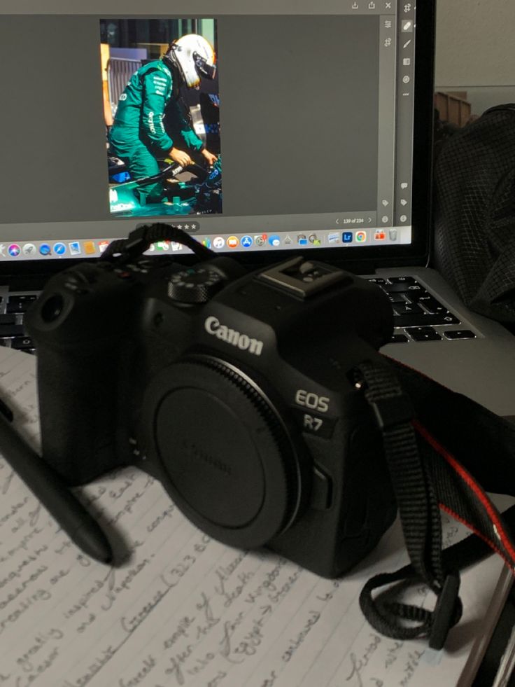 a laptop computer sitting on top of a desk next to a camera