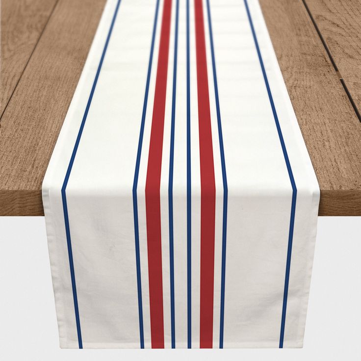 a long table runner with red, white and blue stripes on the edge is sitting on a wooden floor