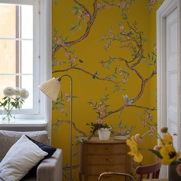 a living room with yellow walls and floral wallpaper