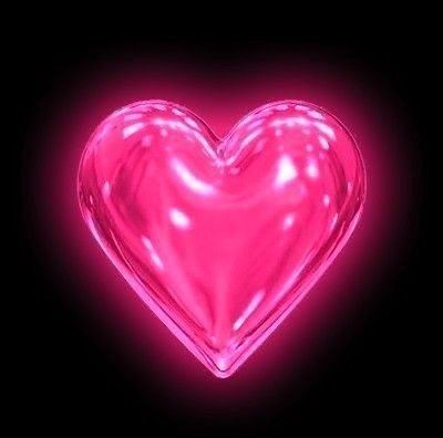 a pink heart shaped object in the dark