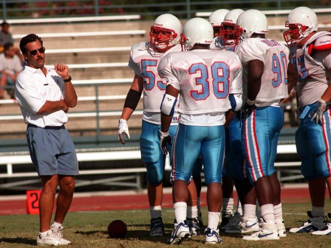 the coach is talking to his team on the sideline during a football game against school