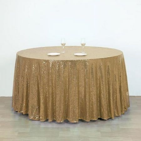 a round table with two wine glasses on it and a gold sequin tablecloth