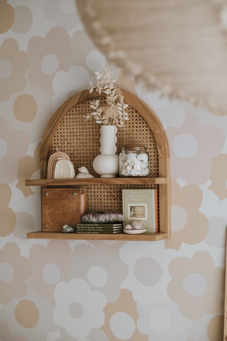 a shelf with some vases and other items on it next to a polka dot wallpaper