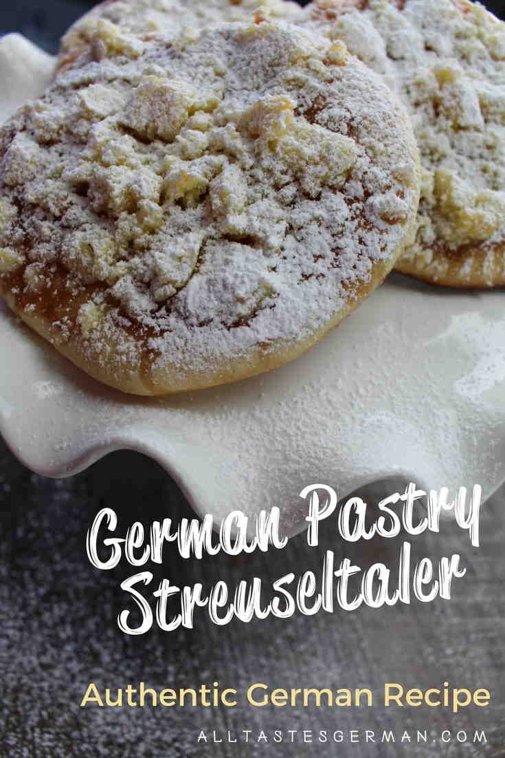 two german pastry streussels sitting on top of a white plate covered in powdered sugar