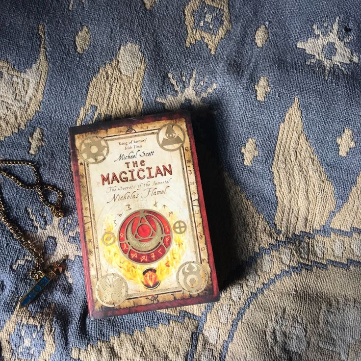 an old book sitting on top of a blue and white blanket next to a chain