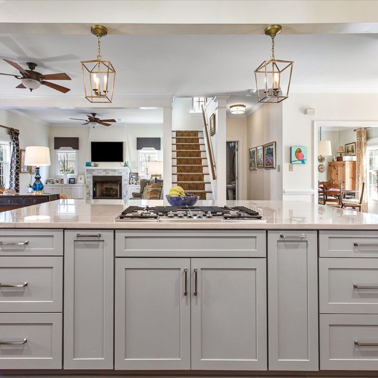 a large kitchen with an island and ceiling fan in it's centerpieces