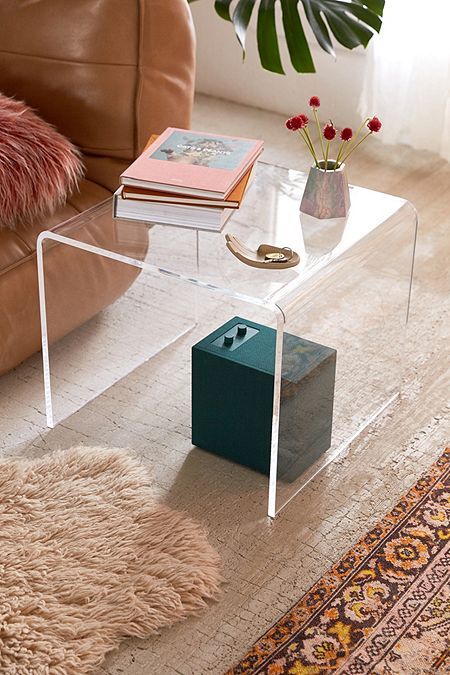 a glass coffee table sitting on top of a rug