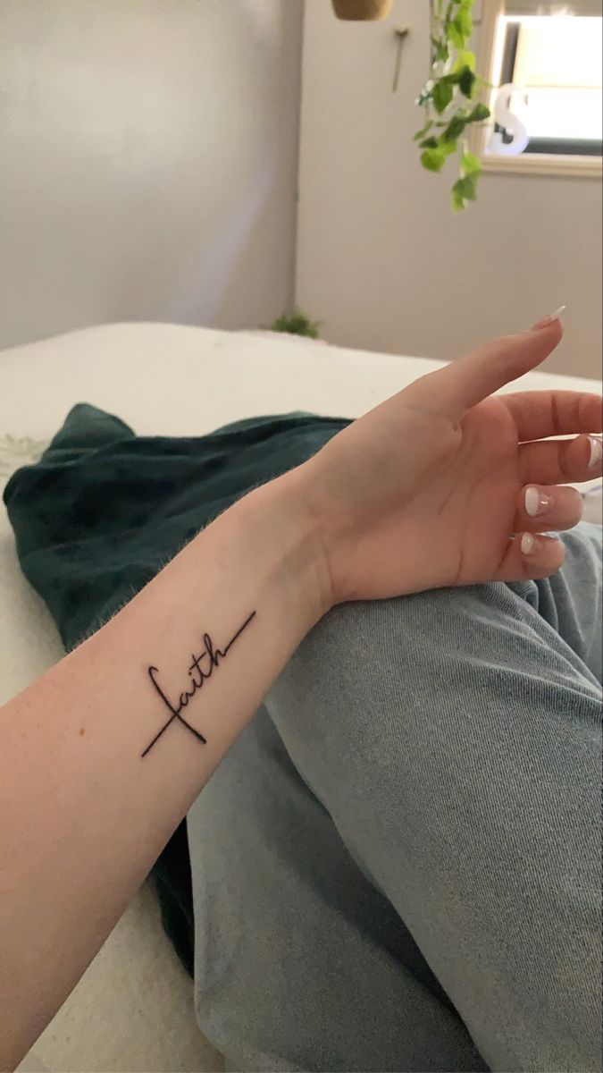 a woman's arm with a small tattoo on it