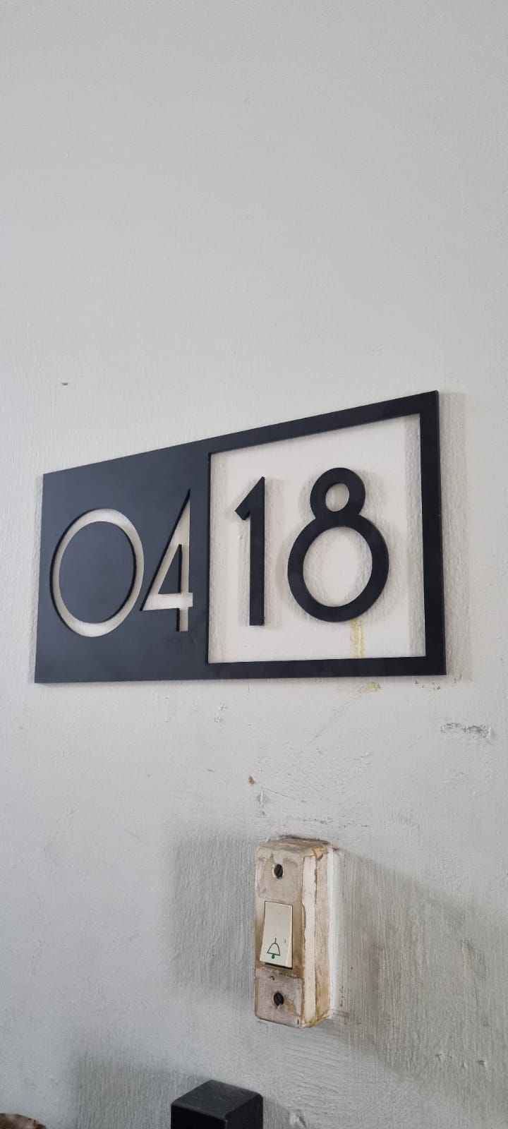 a black and white house number sign mounted to the side of a wall