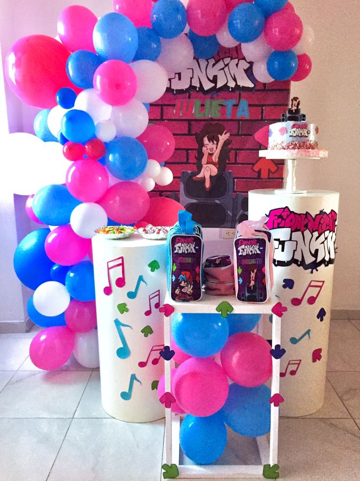 balloons and streamers are on display in front of a brick wall at a birthday party