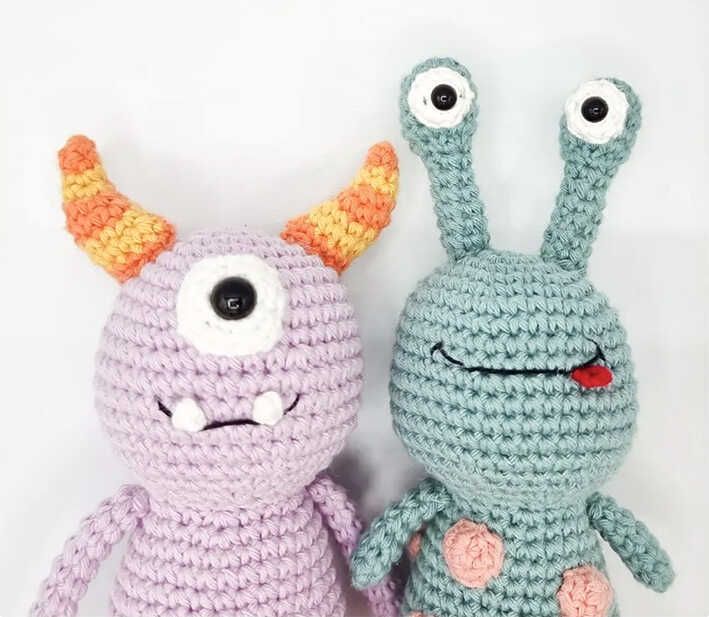 two crocheted stuffed animals sitting next to each other