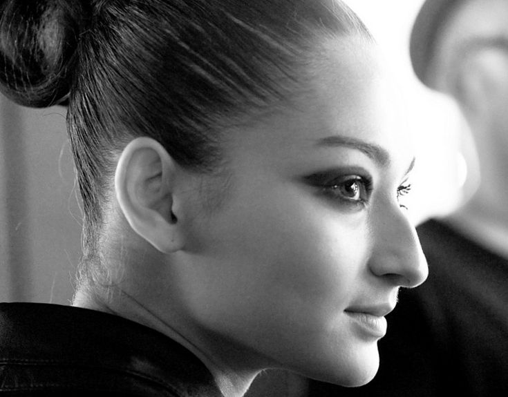 a black and white photo of a woman with her hair in a bun