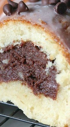 a half eaten chocolate covered doughnut on a cooling rack