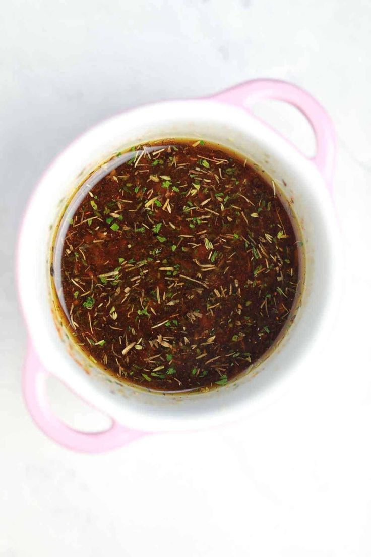 a white bowl filled with some kind of sauce on top of a table next to a spoon