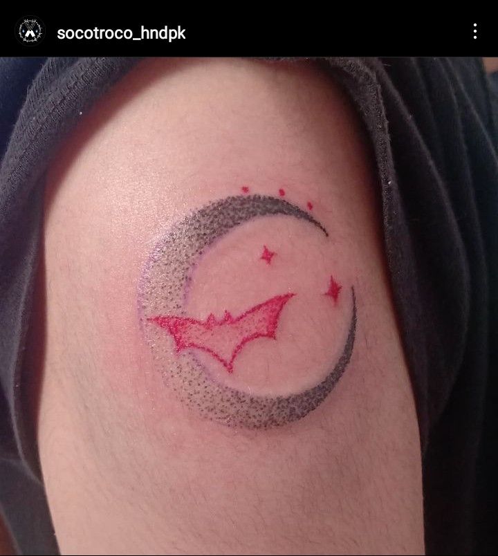 a tattoo on the arm of a person with a crescent moon and stars around it