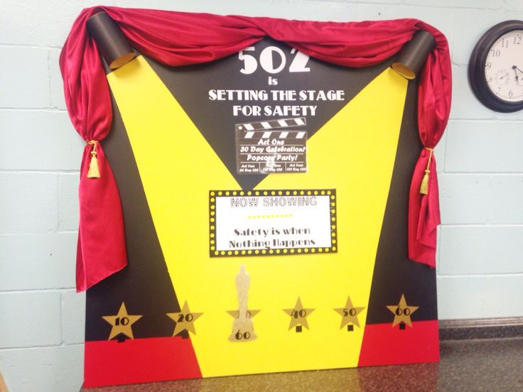 a yellow and red stage curtain sitting on top of a table next to a clock