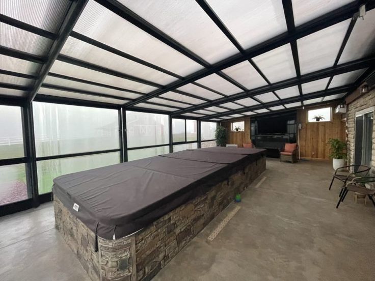 a covered patio area with couches and chairs