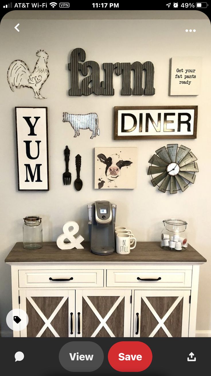 a white cabinet with some pictures on the wall above it and a coffee maker next to it