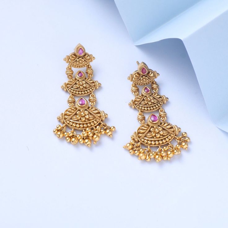 Description Inspired by the shimmering Indian gold jewelry. This Collection is designed to highlight the fine Indian craftsmanship. It is crafted in gold-plated 925 silver with intricate textures and tones. Modern designs adorn you with timeless floral patterns. This jewelry is perfect for wedding and festival events. Created by Paksha design experts, the Swara signature drop earrings gather three floral motifs, coming together in a joyful dance. The pearl drops and pink stones add the right bal Ceremonial 22k Gold Jewelry With Matching Earrings, Festive 22k Yellow Gold Chandelier Earrings, Temple Jewelry Style Gold Plated Drop Bridal Earrings, Gold Plated Drop Bridal Earrings In Temple Style, Gold Plated Drop Earrings For Bridal Temple Jewelry, Ceremonial Matching Earrings For Diwali, Intricate Yellow Gold Danglers, Gold Plated Temple Jewelry Bridal Earrings, Intricate 22k Gold Fusion Earrings