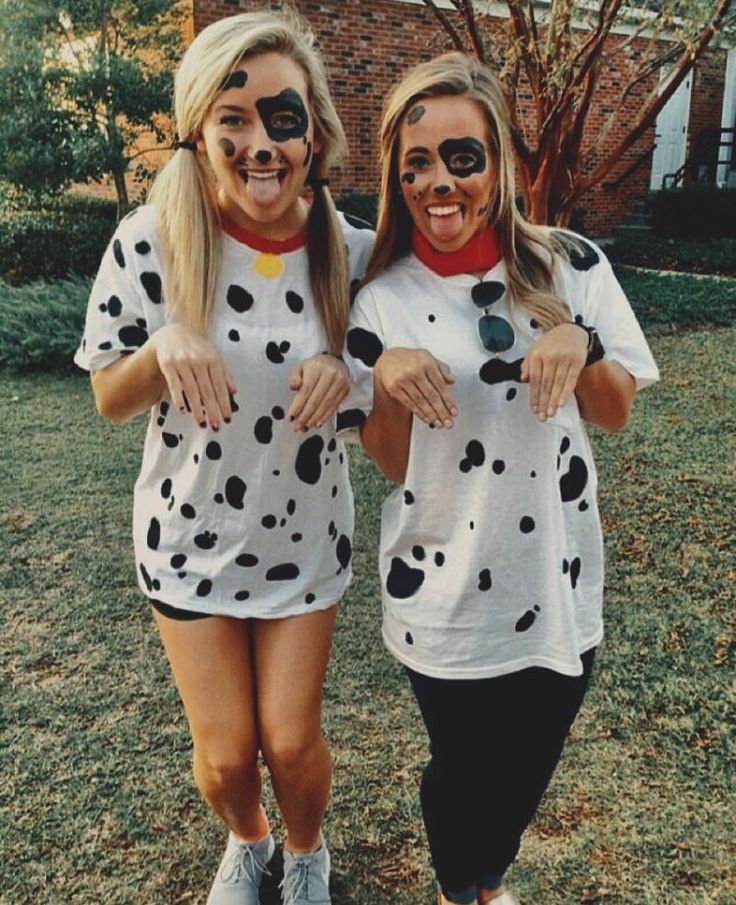 two women with painted faces are standing in the grass