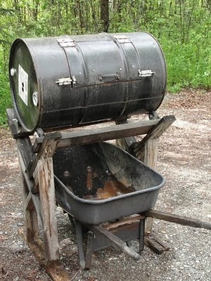 an old barrel sitting on top of a wooden cart